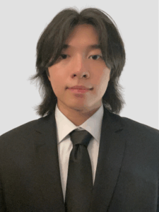 Zhao Wu, a young Chinese man, in a black suit against a grey background.